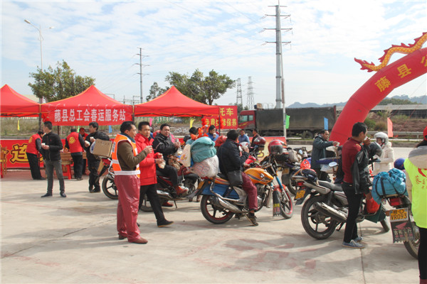 圖為藤縣總工會(huì)在省道304線藤縣陶瓷工業(yè)園區(qū)商業(yè)街小廣場(chǎng)設(shè)立藤縣總工會(huì)為農(nóng)民工平安返鄉(xiāng)“暖流行動(dòng)”服務(wù)站，積極為騎摩托車